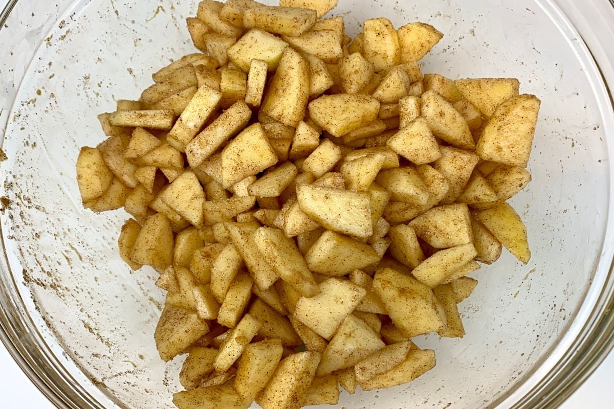Coated apples for apple crisp in bowl.