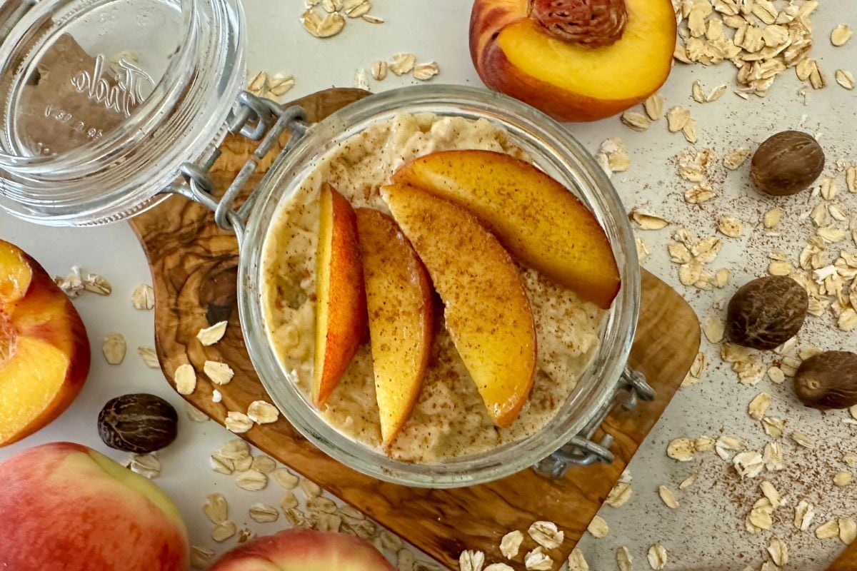 Assembled peach overnight oats topped with fresh peaches
