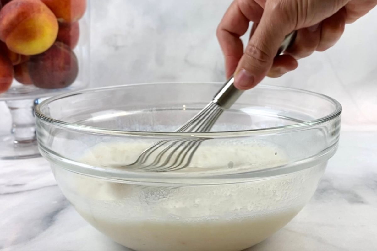 Whisked pudding mixture for peach trifle in a bowl.
