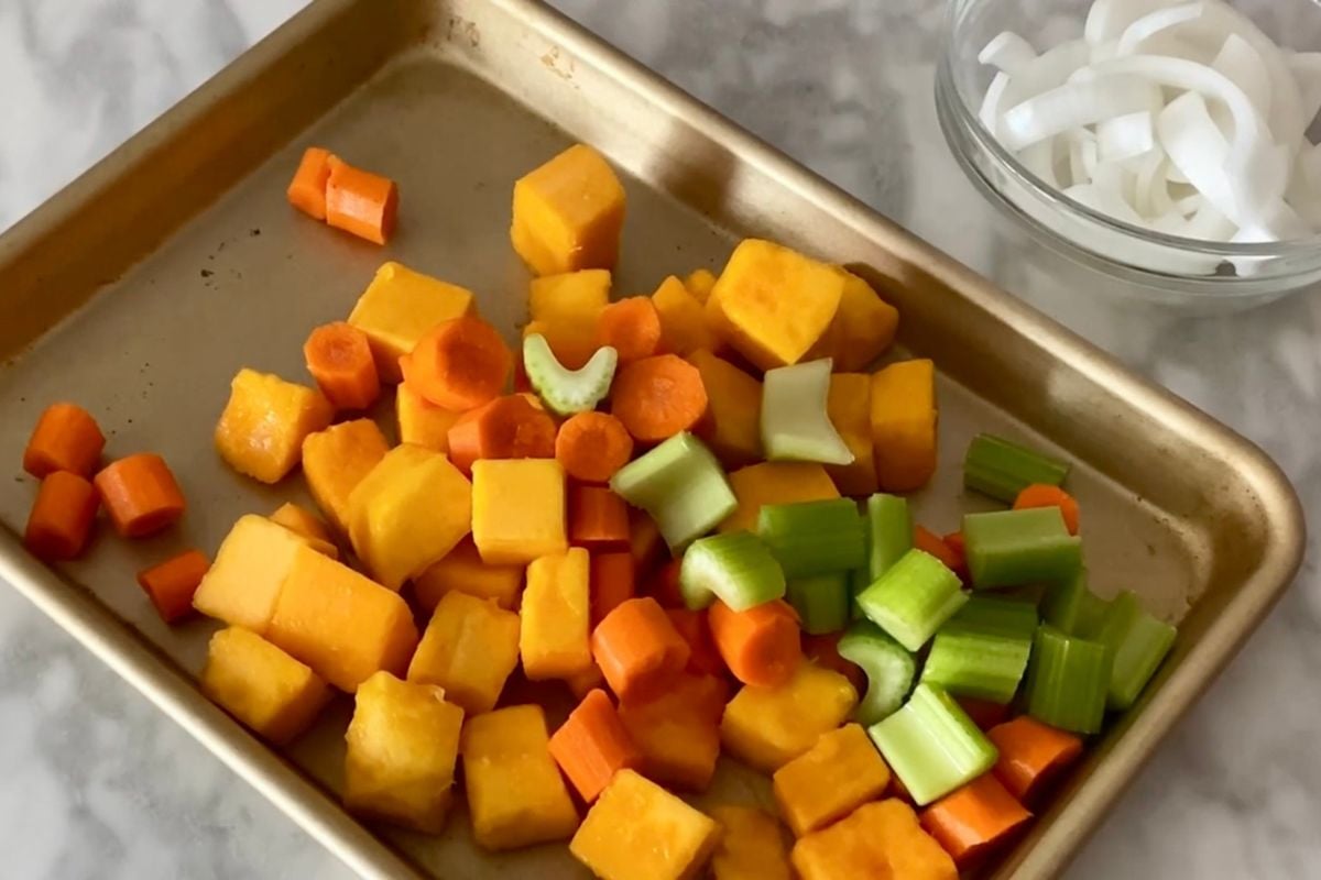 Chopped butternut squash carrots and celery on sheet pan.