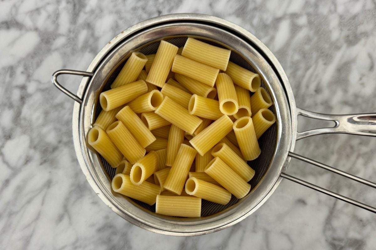 Cooked pasta in a strainer.