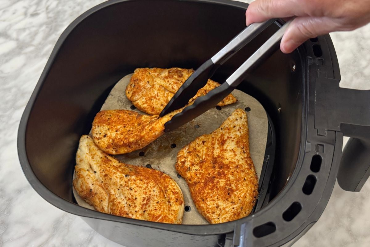 Flipping chicken cutlets to other side in air fryer | Healthy Foodie Girl Flipping chicken cutlets to other side in air fryer