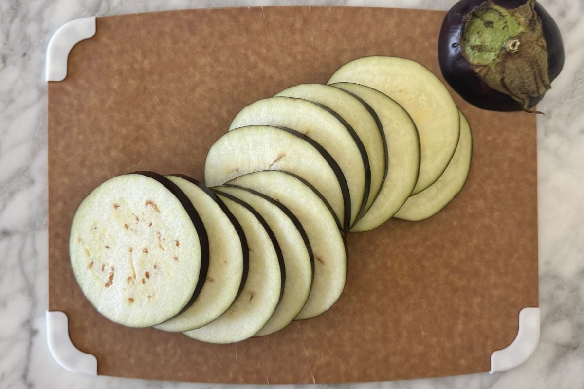 Thinly sliced eggplant on cutting board | Healthy Foodie Girl Thinly sliced eggplant on cutting board