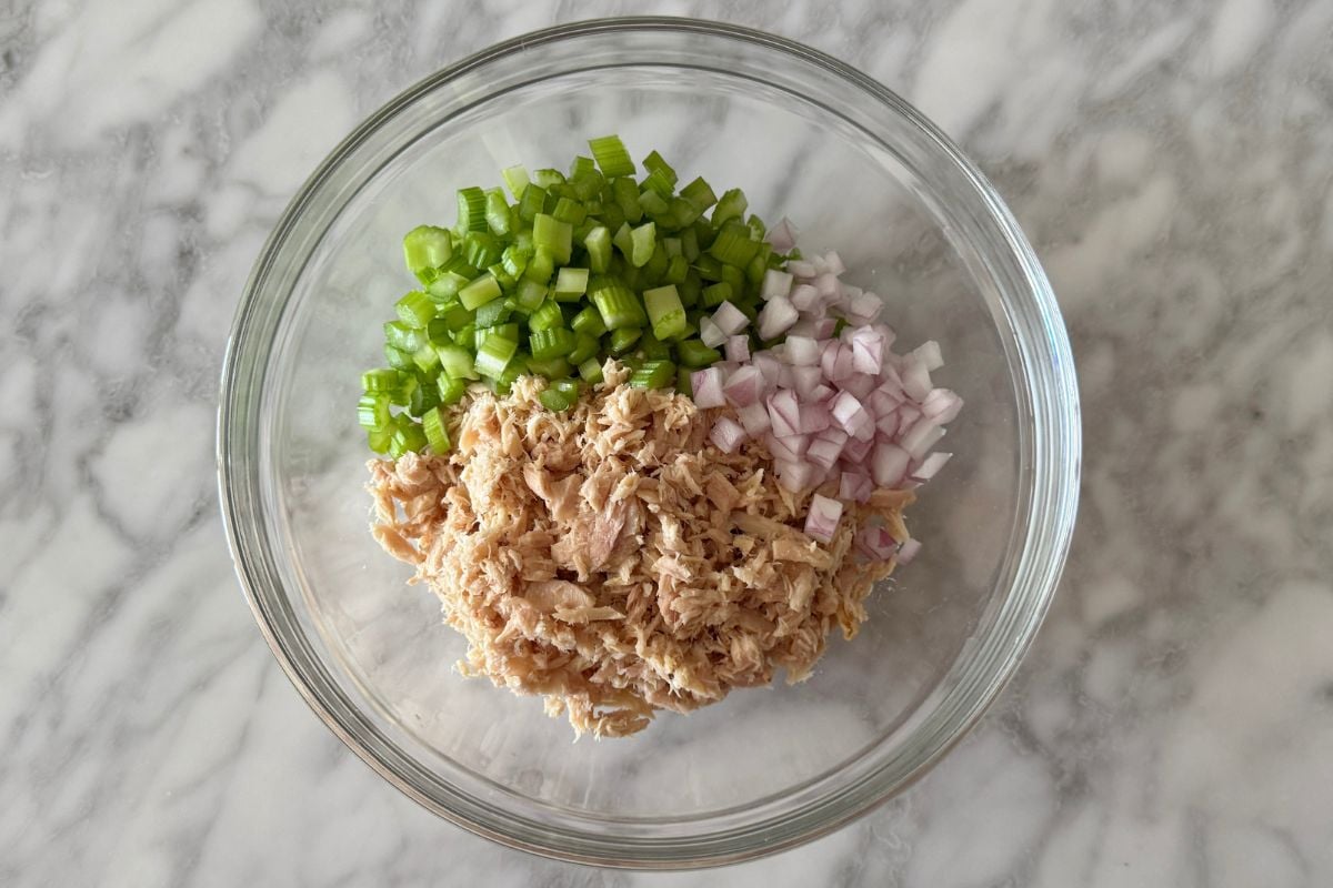 Canned tuna in bowl with celery and red onion