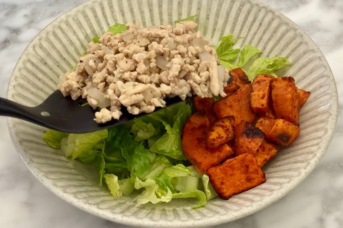 Cooked ground meat on a spatula for burger bowl