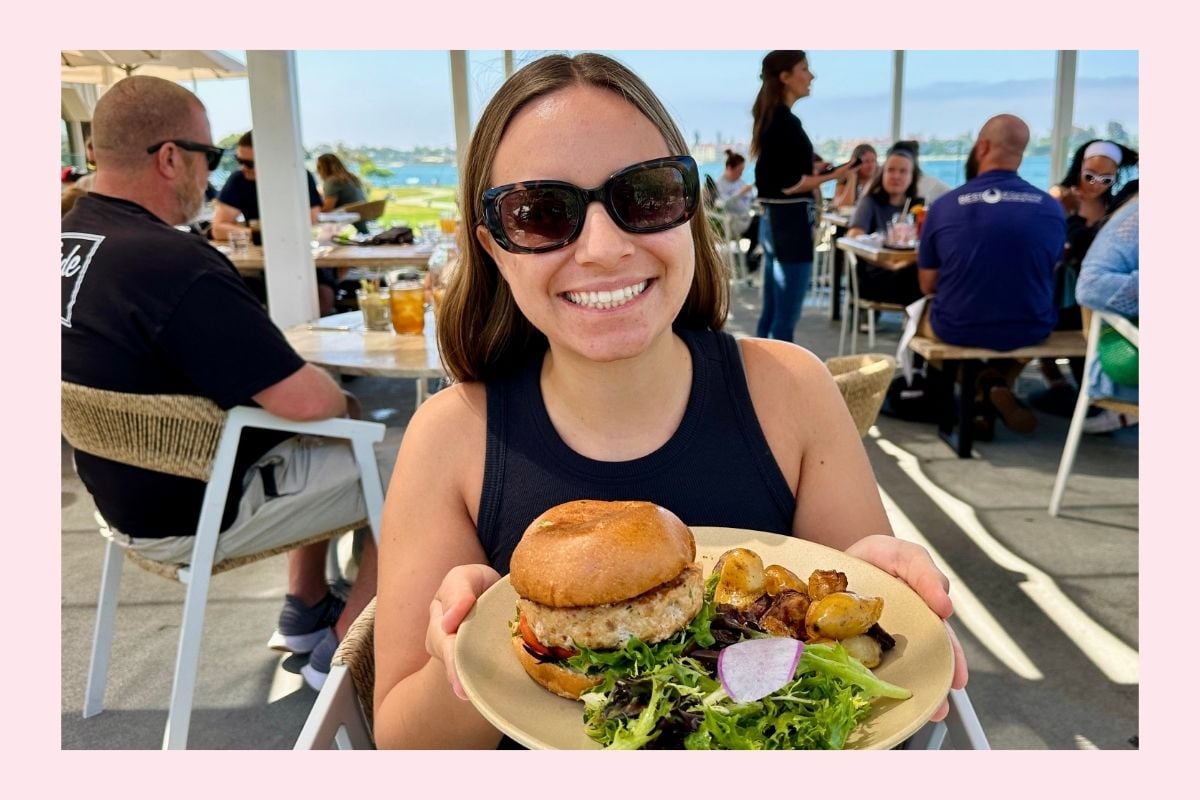Ella from Healthy Foodie Girl holding a plate with a turkey burger