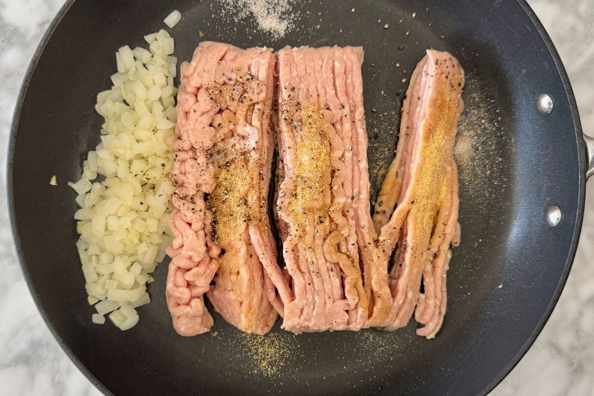 Onion and seasoned ground meat in pan for healthy burger bowls