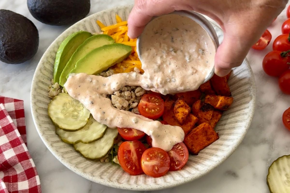 Special sauce drizzled on the burger bowl