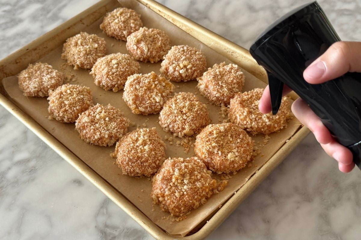 Coated chicken nuggets on a sheet pan