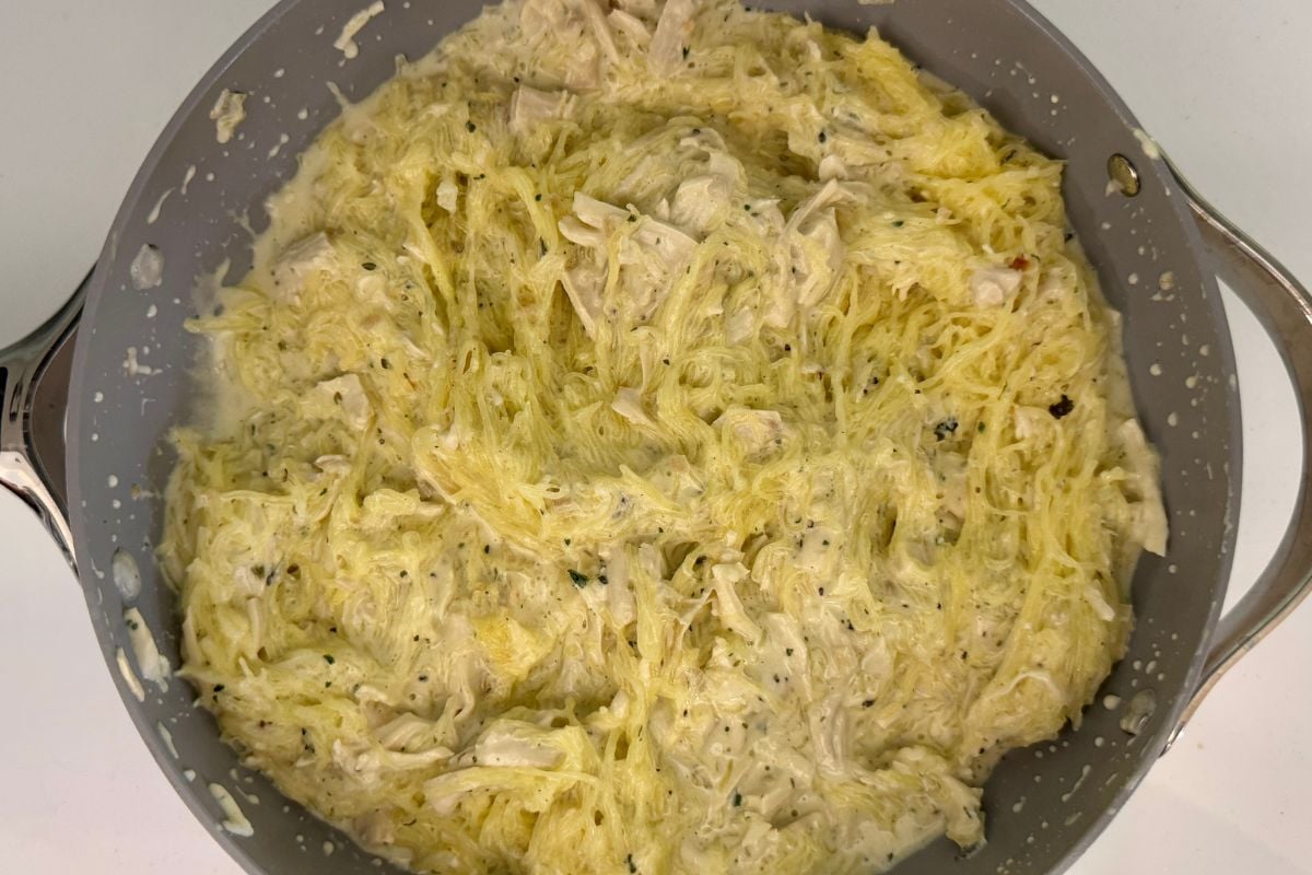 Combined spaghetti squash with Alfredo sauce in a skillet