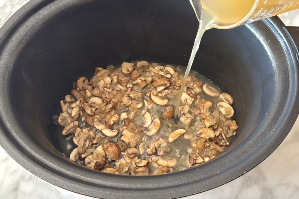 Chicken broth in slow cooker with mushrooms