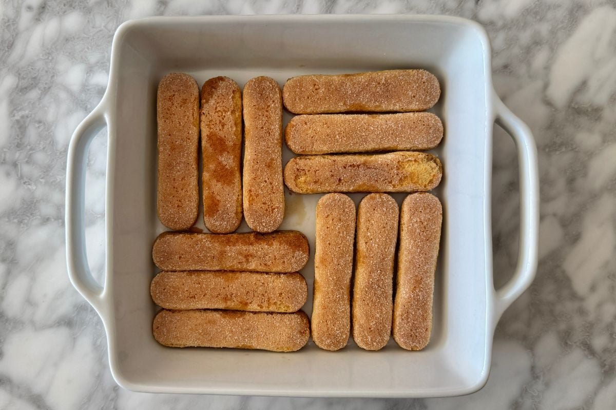 Coffee soaked ladyfingers in a baking dish for tiramisu
