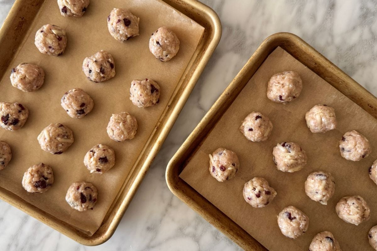 Cranberry apple chicken meatballs formed on sheet pans