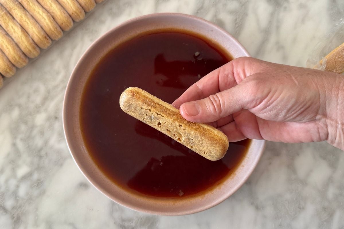 Ladyfinger dipped in cooled coffee for tiramisu