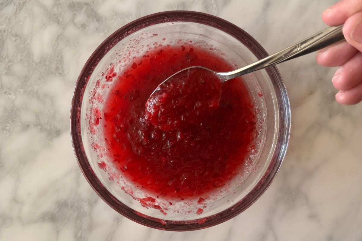 Sauce made with cranberry sauce and chicken broth in bowl