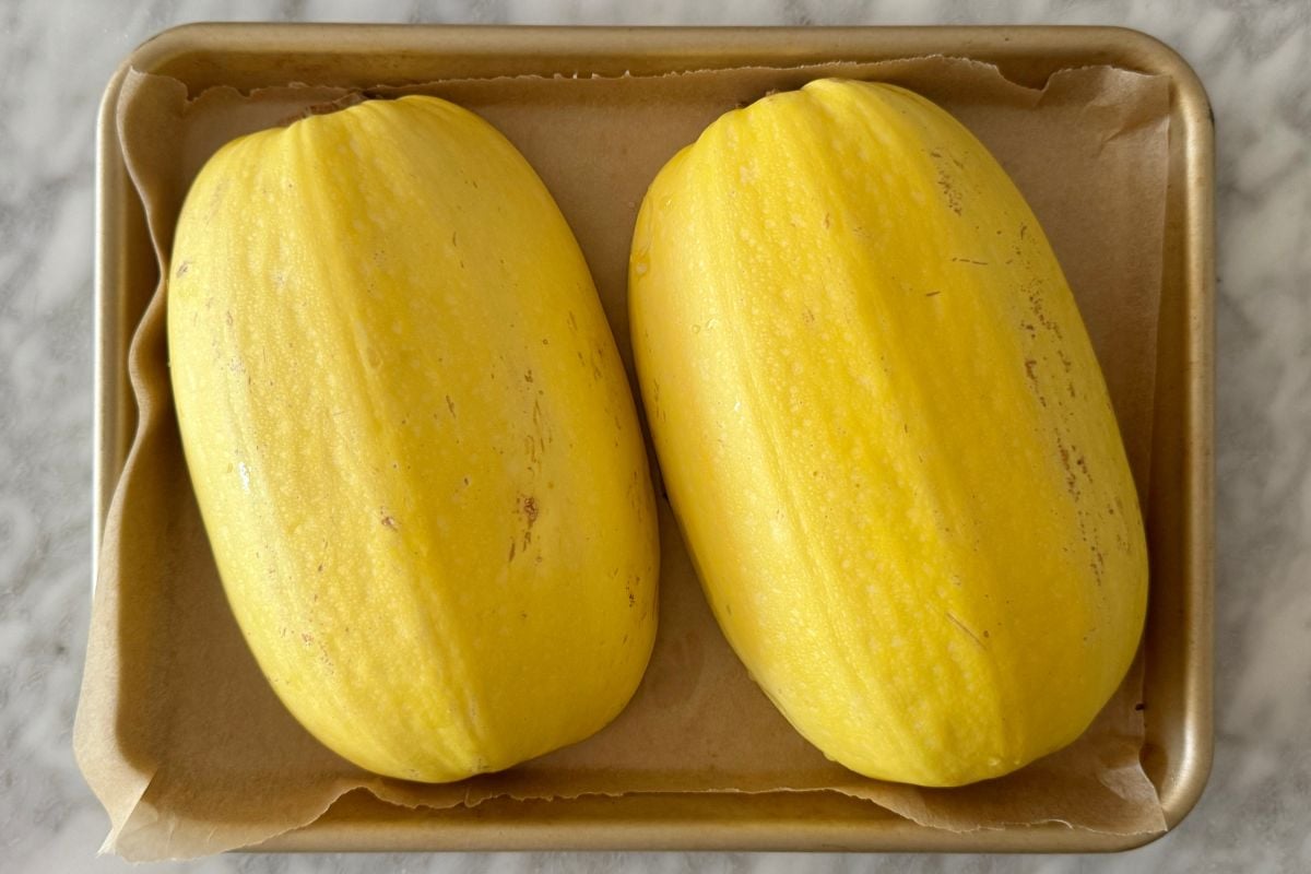 Spaghetti squash halves cut side down on baking sheet | Healthy Foodie Girl Spaghetti squash halves cut side down on baking sheet