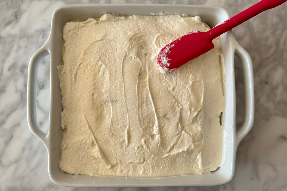 Whipped topping spread on eggnog tiramisu