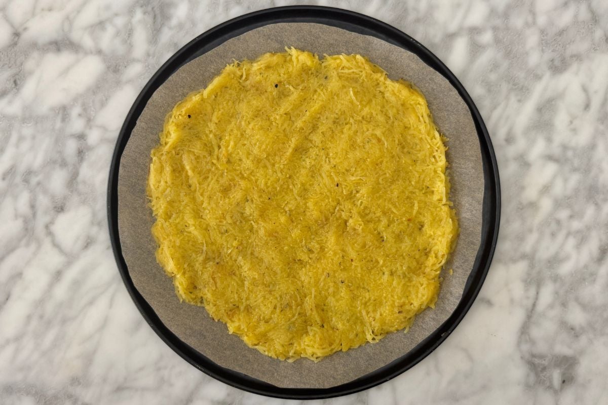 Formed spaghetti squash pizza crust on pizza pan