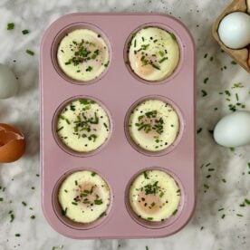 Muffin Tin Baked Eggs Recipe in a muffin pan topped with chives.