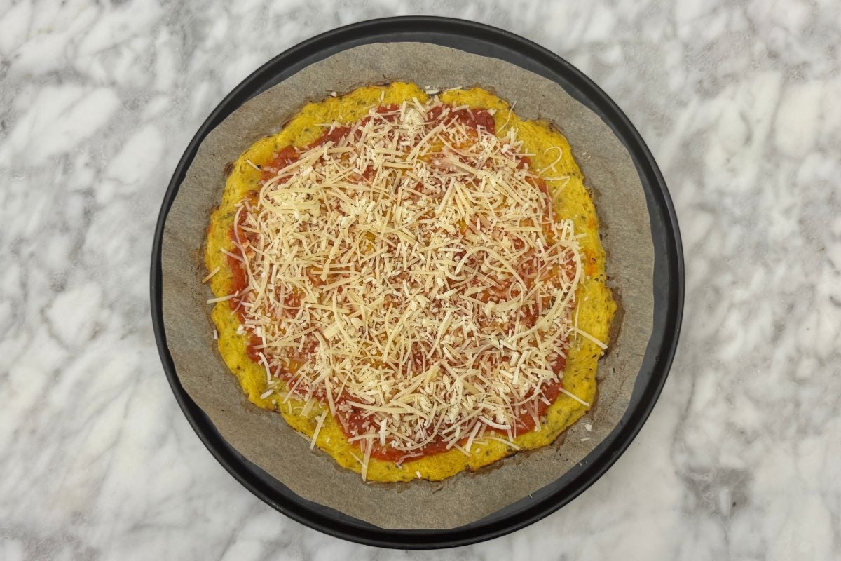Spaghetti squash crust topped with pizza sauce and cheese
