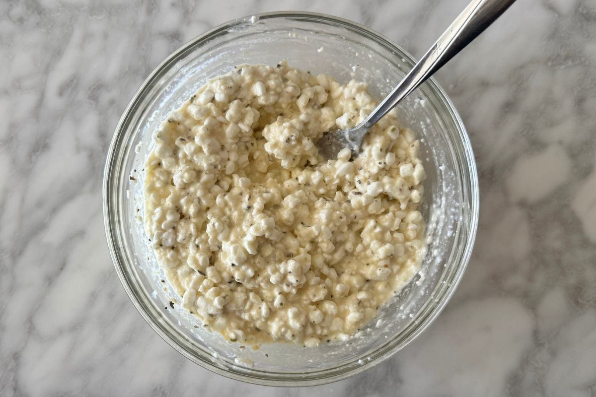 Mixed cottage cheese mixture in bowl for lasagna.