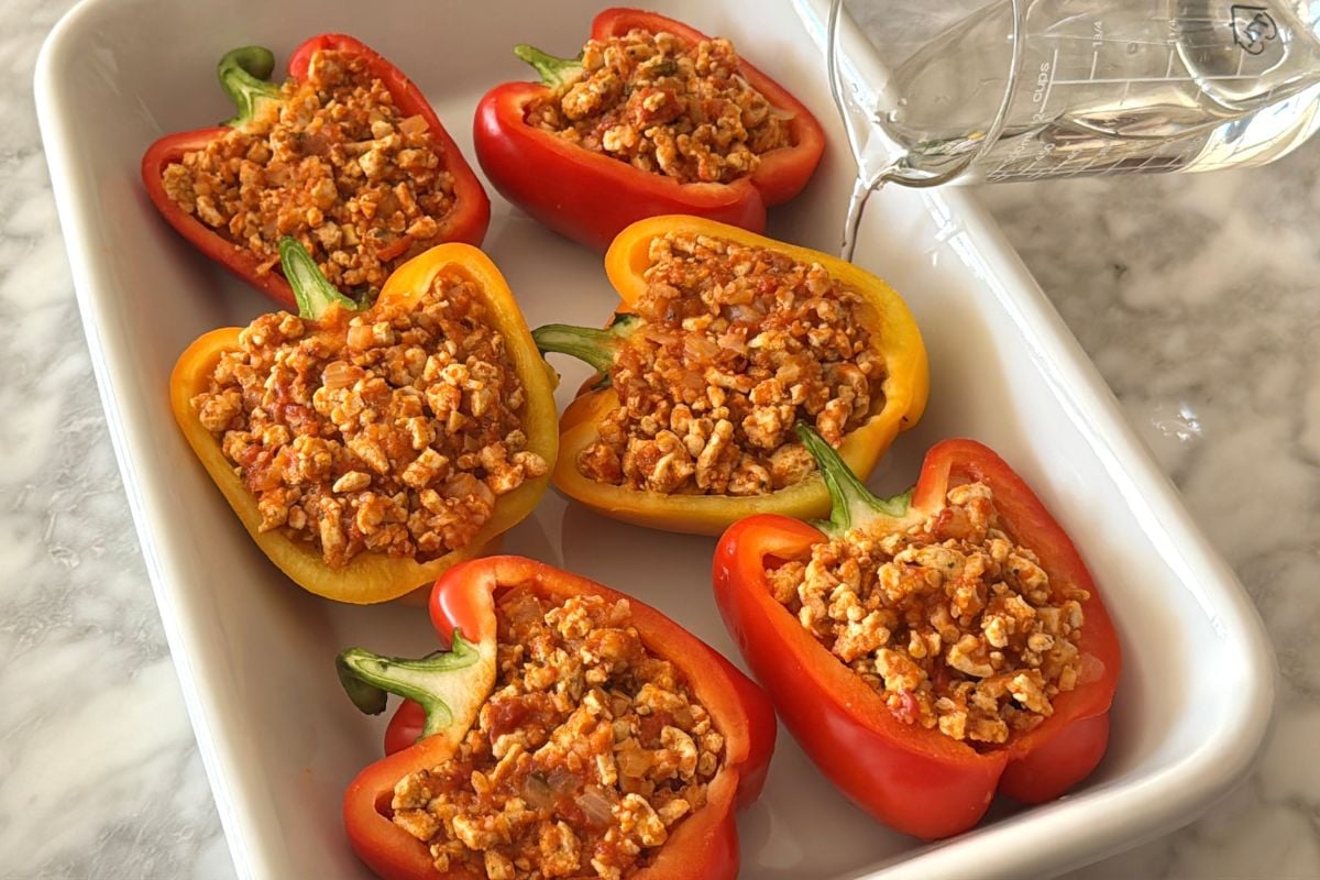 Water poured in baking dish for stuffed peppers | Healthy Foodie Girl Water poured in a baking dish for stuffed peppers.