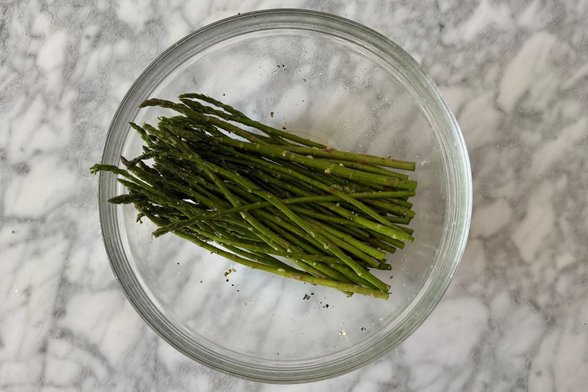 Seasoned asparagus in a bowl.