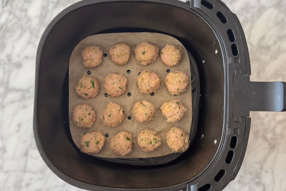 Turkey meatballs in air fryer basket.