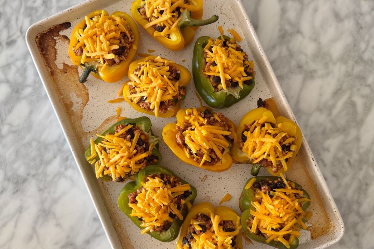 Baked stuffed peppers topped with shredded cheese.