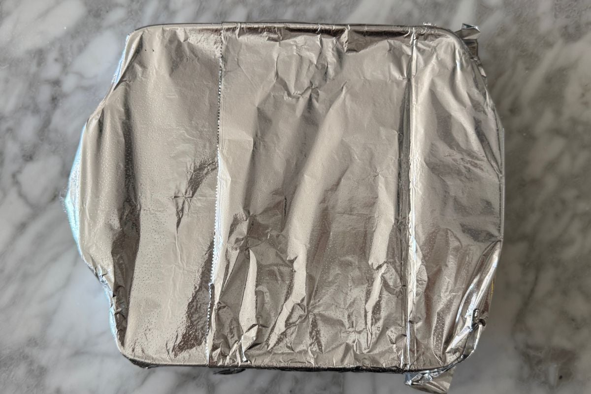 Baking dish with lasagna covered with foil.