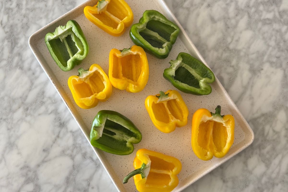 Prepared bell peppers on a sheet pan.