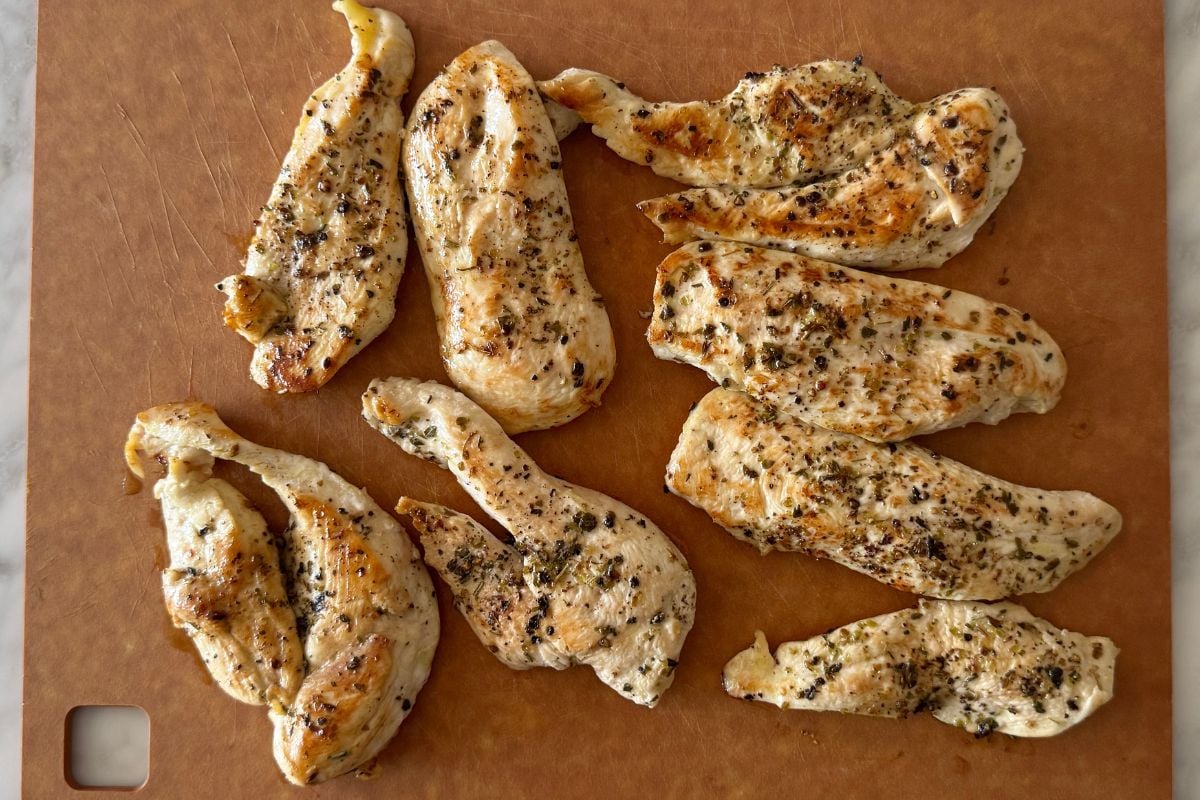 Cooked chicken resting on a cutting board.