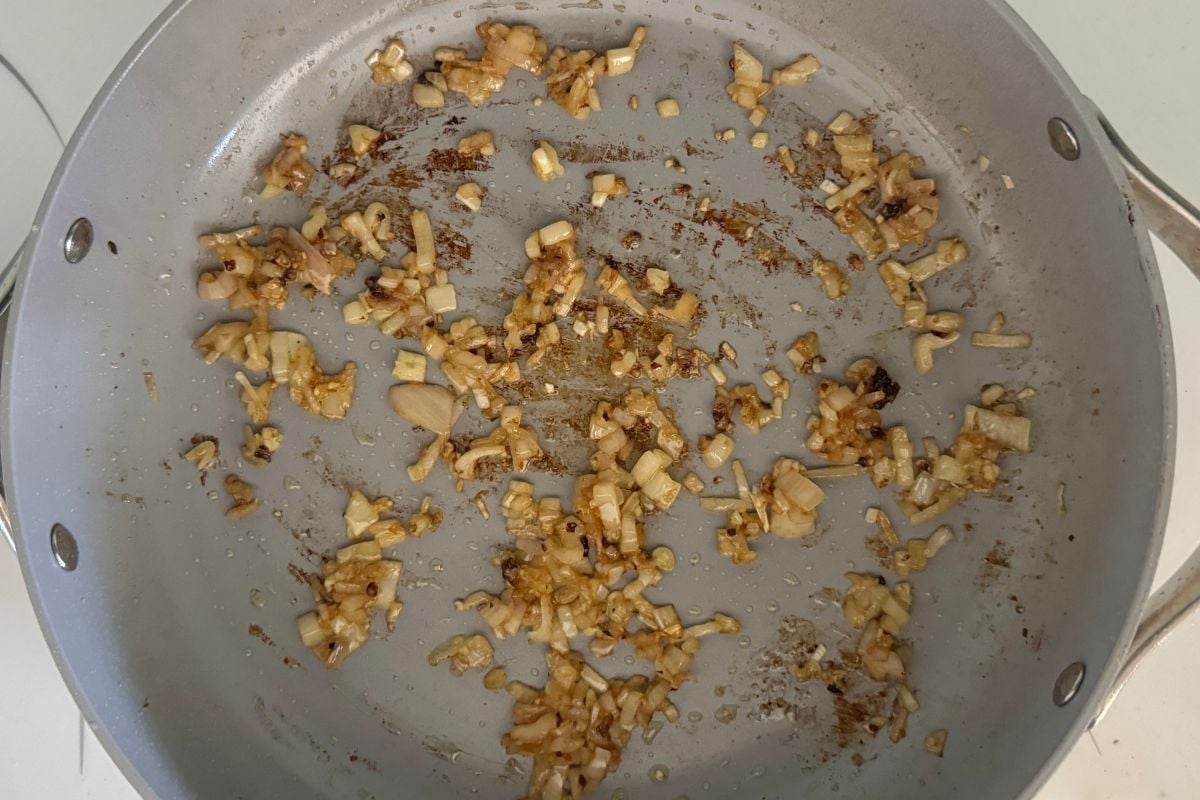 Cooked shallots and garlic in a pan.