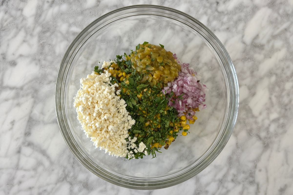 Corn in bowl with green chiles onion and cheese | Healthy Foodie Girl Corn in bowl with green chiles onion and cheese.