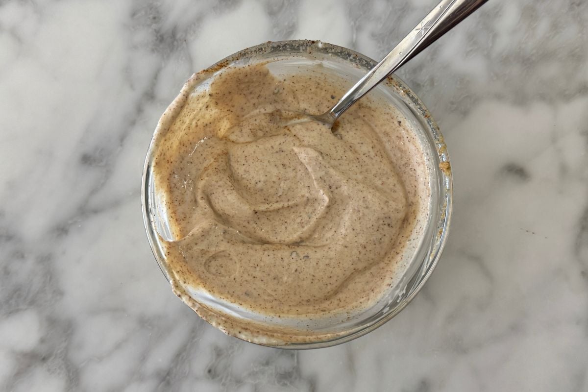 Mixed Greek yogurt dressing for tuna salad in bowl.