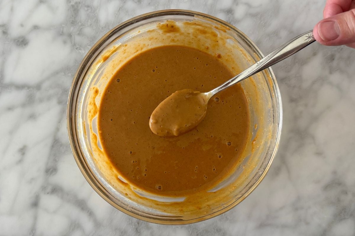 Mixed spicy peanut sauce with PB2 for peanut noodles in a bowl.