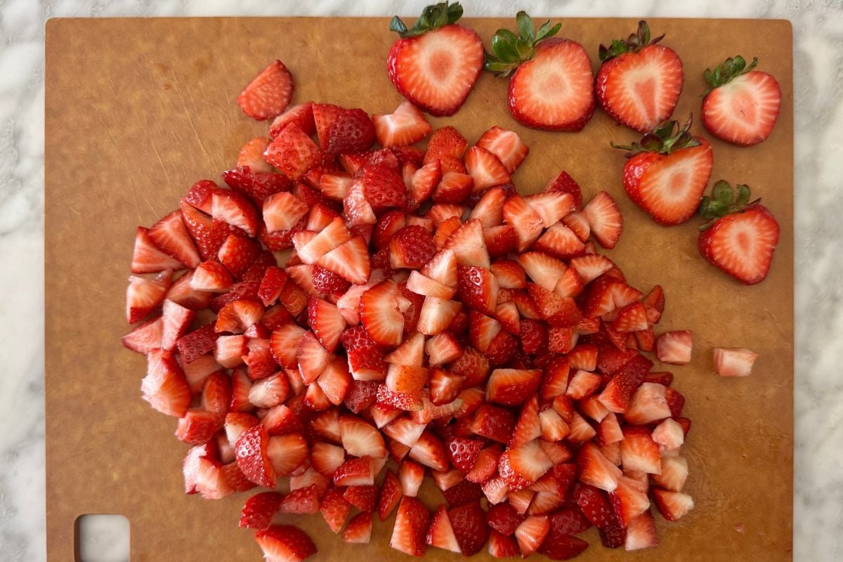 Chopped strawberries on a cutting board.