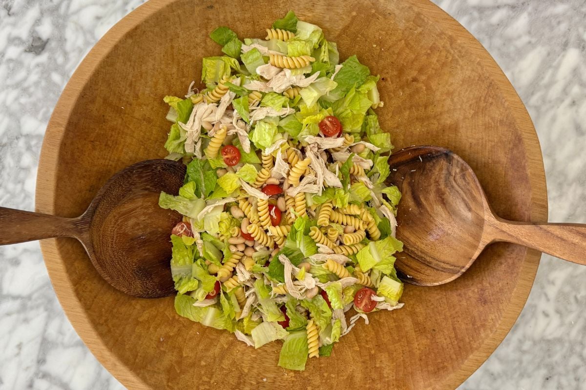 Tossed chicken Caesar pasta salad in a bowl.