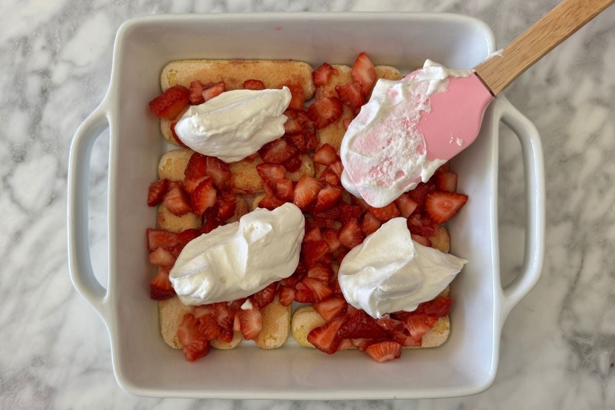 Whipped topping over strawberries and ladyfingers.