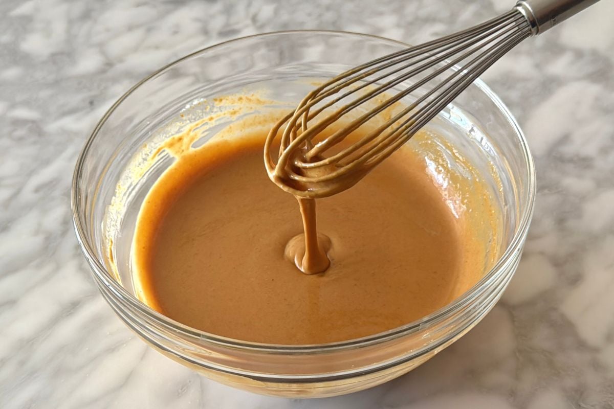Whisked healthy Thai peanut dressing in a bowl | Healthy Foodie Girl Whisked healthy Thai peanut dressing in a bowl.