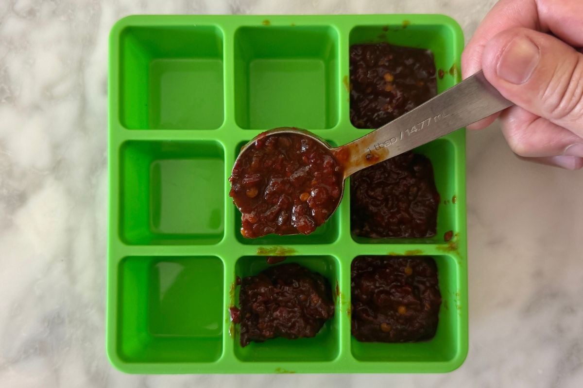 Chipotle peppers in adobo sauce in an ice cube tray.