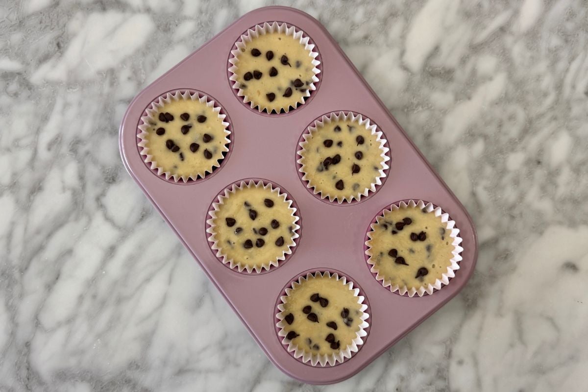 Chocolate chip muffin batter in a muffin pan | Healthy Foodie Girl Chocolate chip muffin batter in a muffin pan.