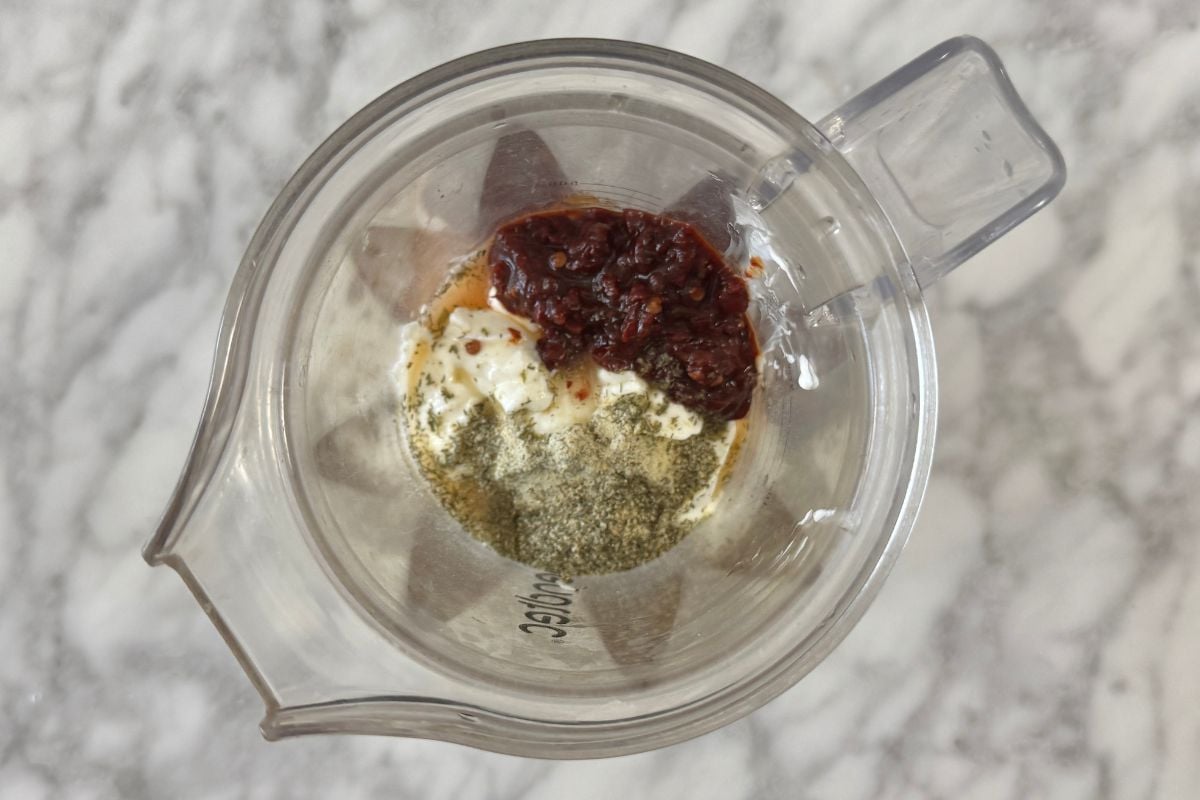 Greek yogurt and chipotle peppers in adobo sauce in a blender.
