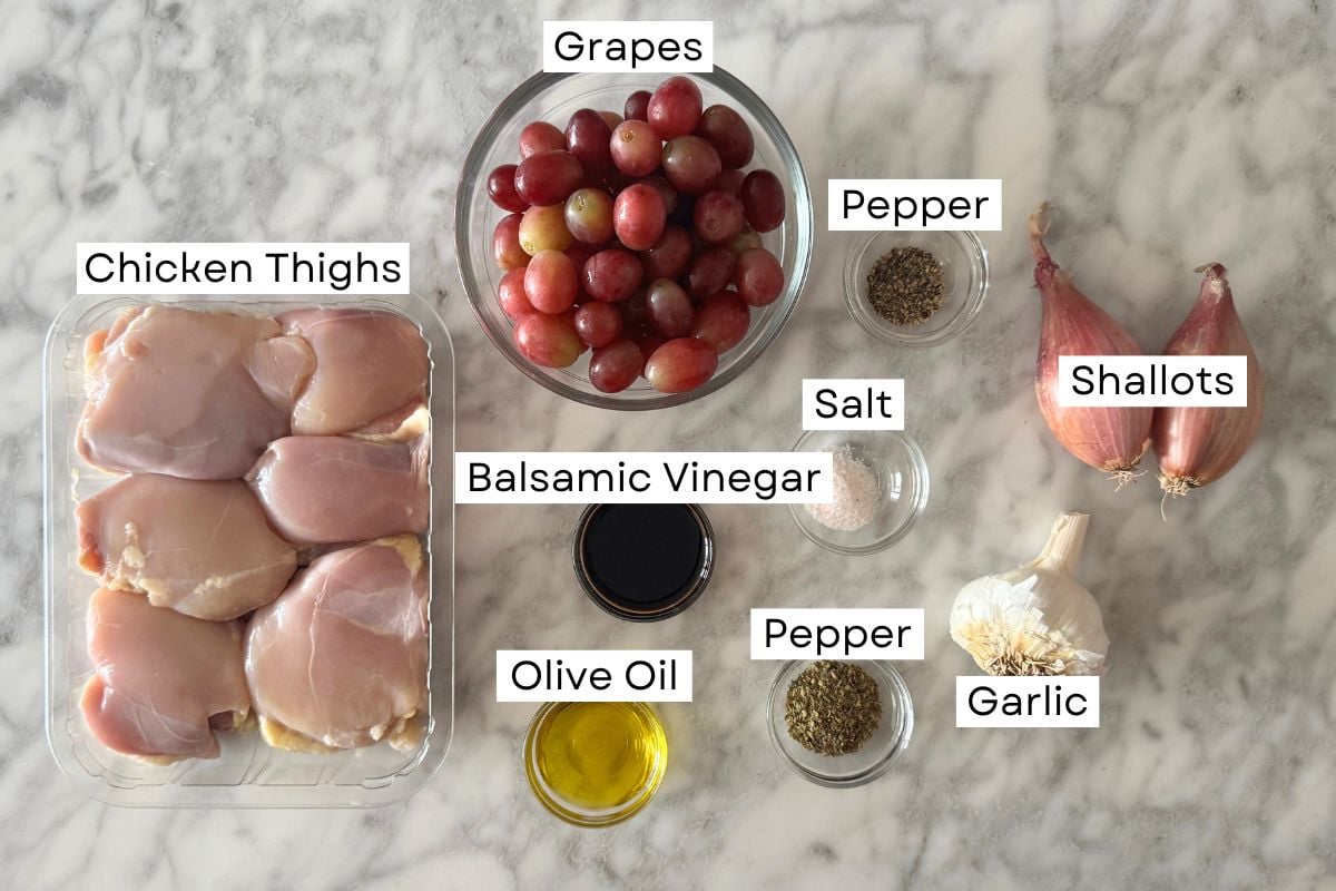 Ingredients for sheet pan chicken with grapes and shallots in bowls.