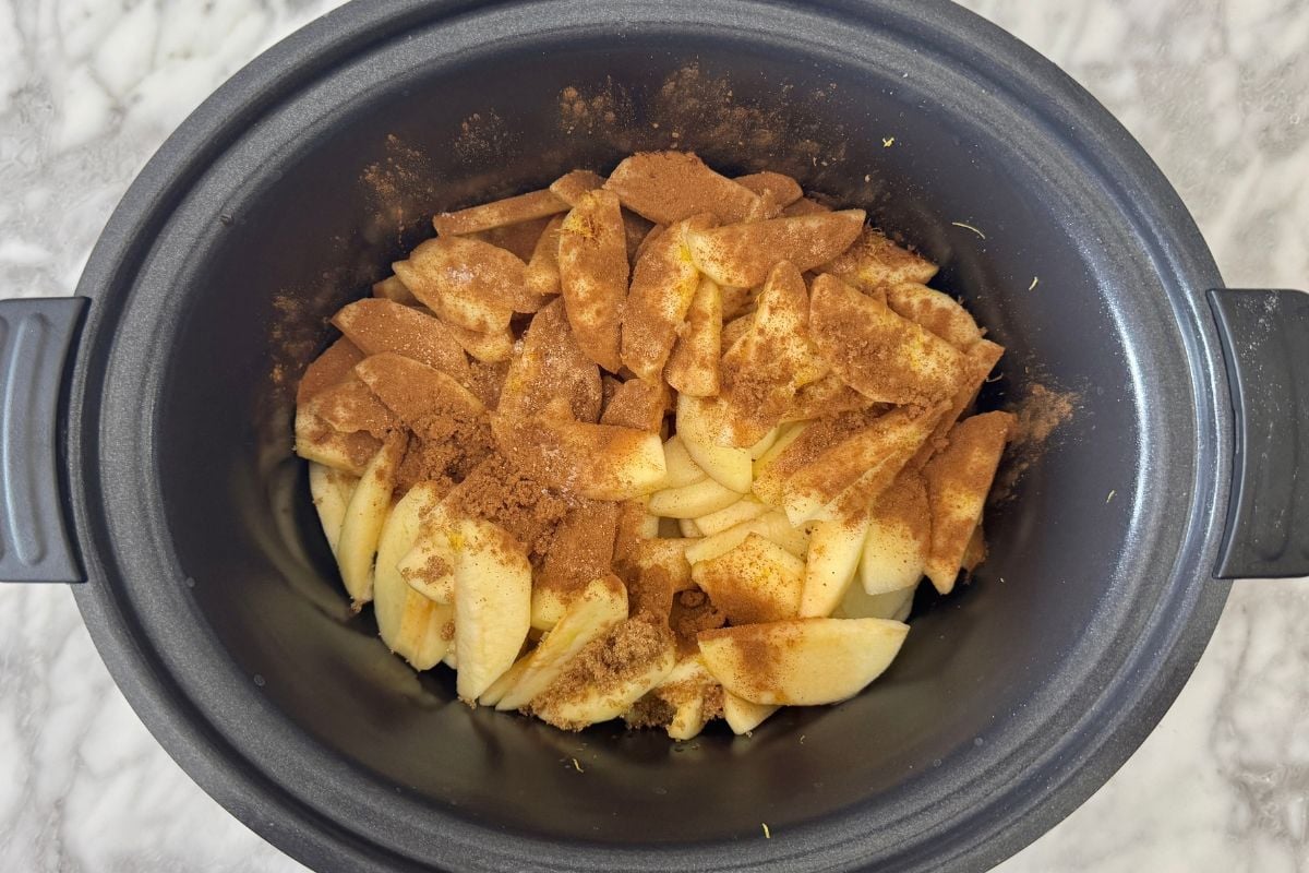 Sliced apples with cinnamon in a slow cooker.