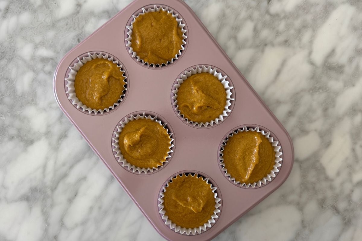 Pumpkin batter in a muffin pan.